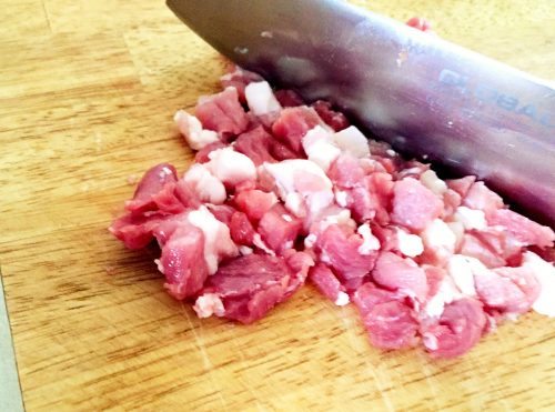 餃子の作り方１：豚バラのブロック肉を包丁で叩いて細かくする