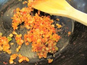 エビチリの作り方。フライパンにねぎ、にんにく、しょうが、ケチャップ、豆板醤を入れたら、弱火でじっくりと炒める。